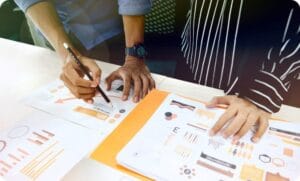 CMA 자격증 취득을 위한 CMA 자격요건 가이드 4 two people having a business meeting with a pencil and paper reports