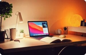 a laptop and a open book in a study room with good ambient