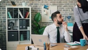 a man and a woman looking at each other in an office working together