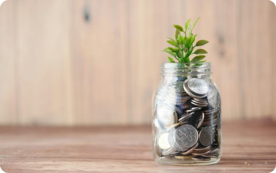 a glass jar filled with coins and a plant