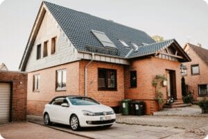 a white vehicle parked beside a house
