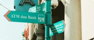 a road sign in green pointing ATM dan Bank