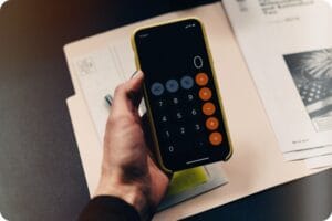a calculator app on a smartphone with tax documents on the table