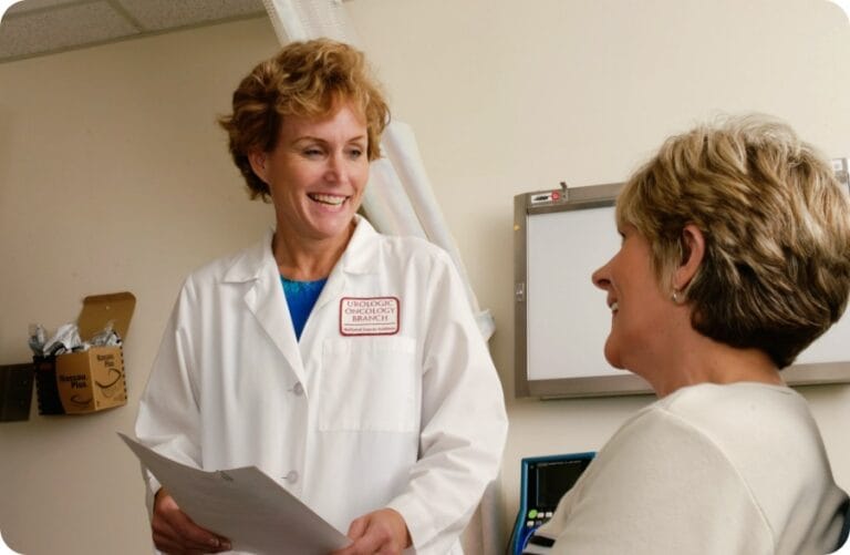 a doctor wearing a white scrub smiling at a patient