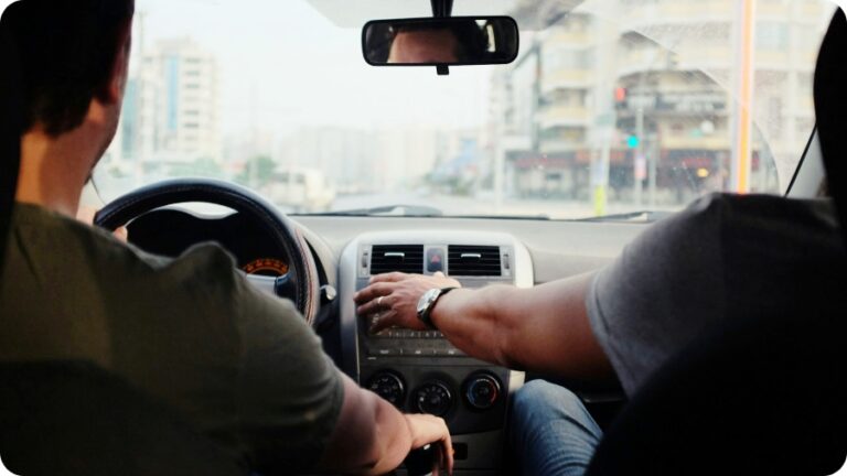 a driver and a passenger sitting inside a vehicle driving on a road