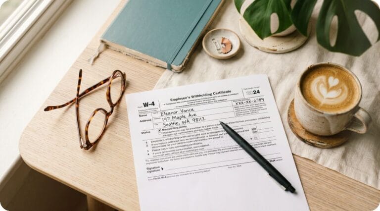 W-4 세금 양식과 펜, 커피잔이 놓인 책상 플랫레이 이미지